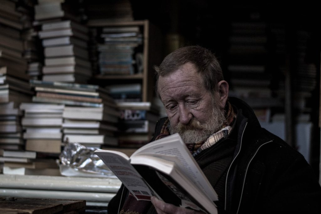 senhor de idade lendo um livro