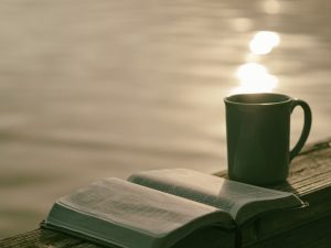 um livro aberto com uma caneca ao lado na ´praia